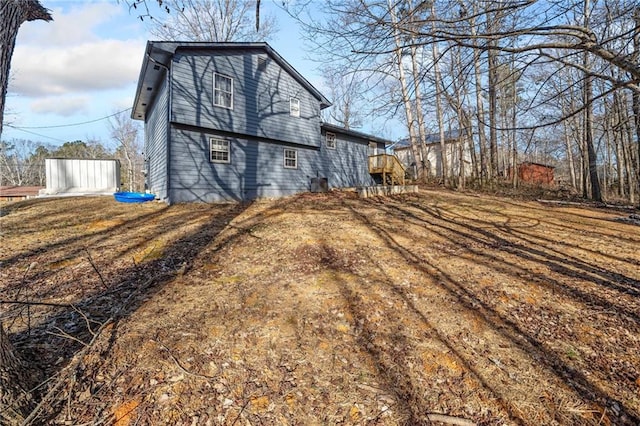 view of side of property featuring a wooden deck and a lawn