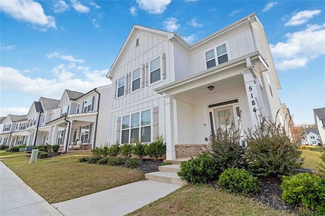 townhome / multi-family property featuring a front yard and a porch