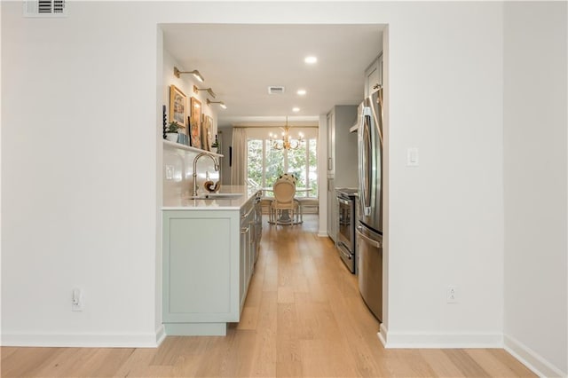 39 Ivy Gates NE, Atlanta, GA 30342 - kitchen featuring a sink, light countertops, light wood-type flooring, and an inviting chandelier