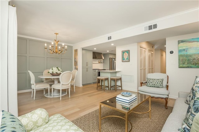 39 Ivy Gates NE, Atlanta, GA 30342 - living room with visible vents, an inviting chandelier, a decorative wall, ornamental molding, and light wood finished floors