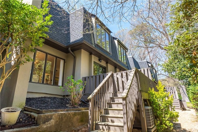 39 Ivy Gates NE, Atlanta, GA 30342 - view of property exterior with central air condition unit, stairway, stucco siding, and roof with shingles