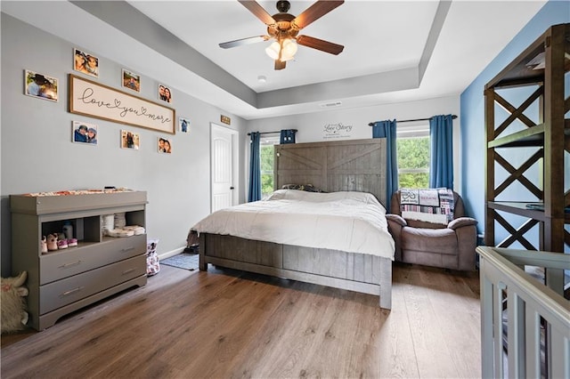 200 Lower Dove Ct, Ball Ground, GA 30107 - bedroom featuring a raised ceiling, wood finished floors, and ceiling fan
