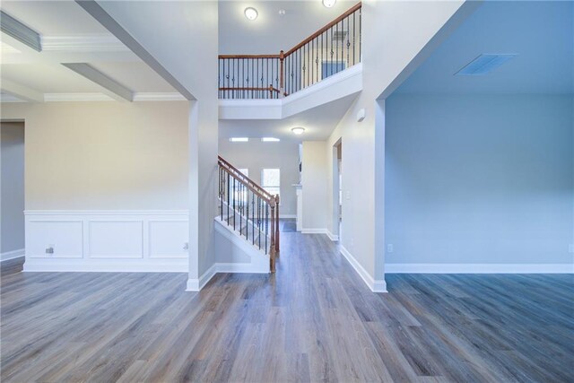 entryway with beamed ceiling and wood-type flooring