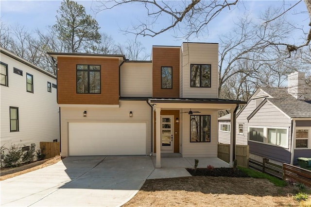 contemporary home featuring covered porch, driveway, an attached garage, and fence