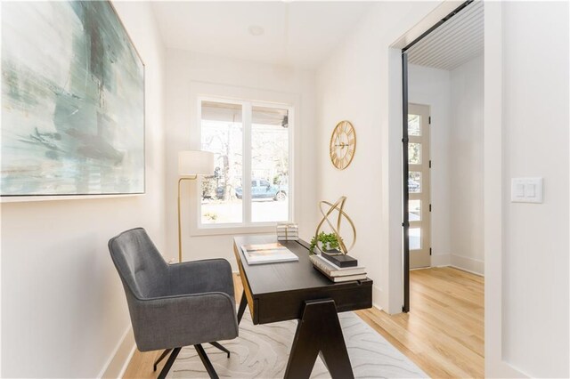 office space featuring baseboards and light wood finished floors