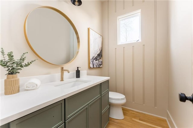 bathroom featuring vanity, toilet, and wood finished floors