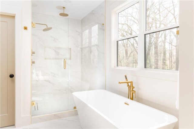 bathroom with a freestanding tub, a marble finish shower, and marble finish floor