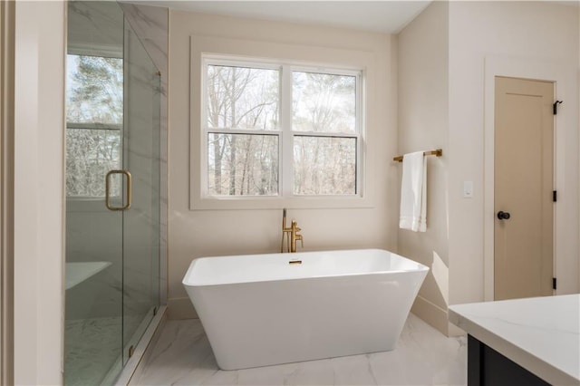 bathroom with a stall shower, a wealth of natural light, marble finish floor, and a freestanding tub