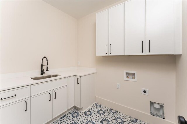 clothes washing area with hookup for an electric dryer, washer hookup, a sink, cabinet space, and light floors