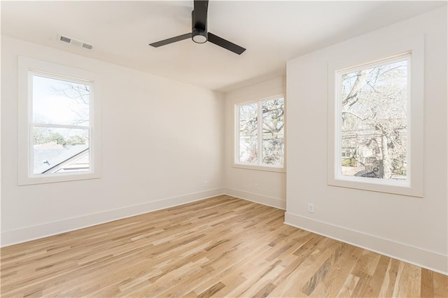 unfurnished room featuring light wood-style floors, baseboards, visible vents, and ceiling fan