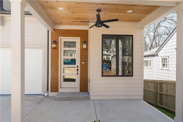 view of exterior entry with fence and ceiling fan