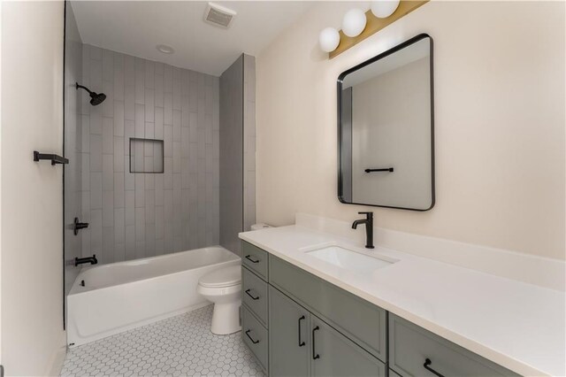 bathroom featuring shower / bath combination, visible vents, toilet, tile patterned floors, and vanity