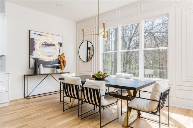 kitchen with tasteful backsplash, high end refrigerator, white cabinetry, and light wood-style floors