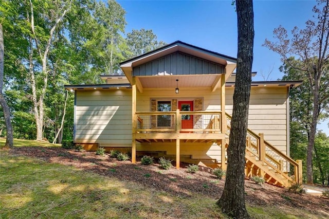 back of house featuring board and batten siding, a porch, and stairway