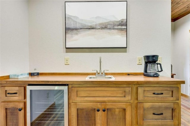 bar with wet bar, beverage cooler, and a sink