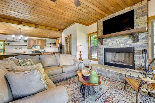 living area with a chandelier, beam ceiling, a fireplace, and wood ceiling