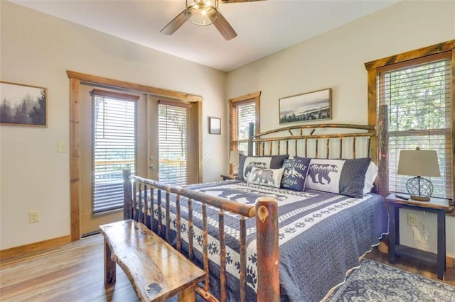 bedroom featuring french doors, a ceiling fan, wood finished floors, access to outside, and baseboards