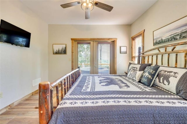 bedroom with ceiling fan, wood finished floors, visible vents, baseboards, and access to outside