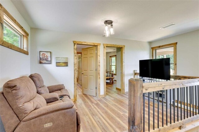 living area with light wood finished floors, baseboards, and visible vents