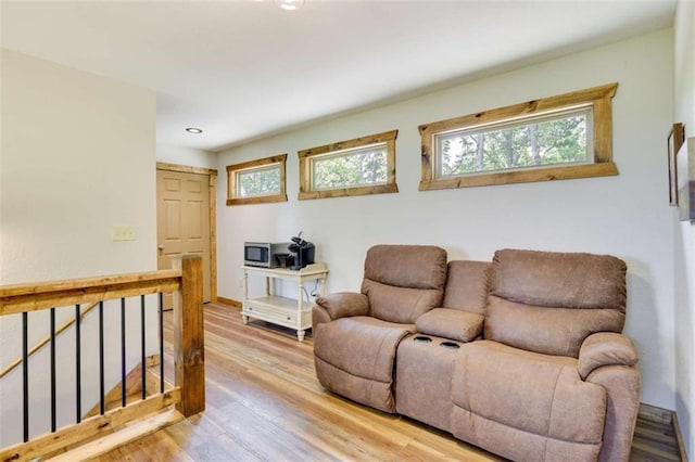 sitting room with recessed lighting, wood finished floors, and an upstairs landing