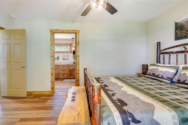 bedroom featuring connected bathroom, a ceiling fan, and wood finished floors