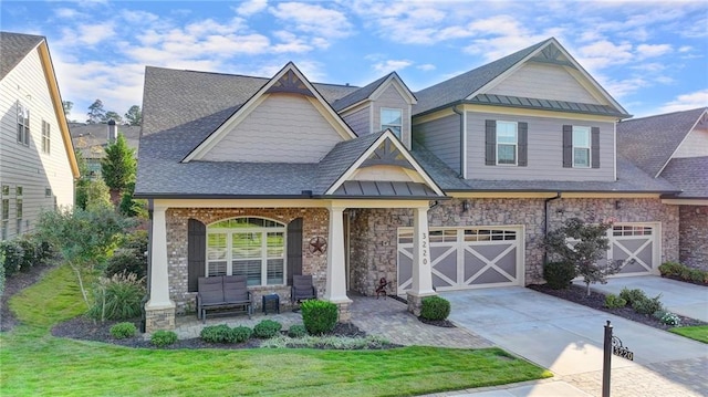 craftsman inspired home with metal roof, driveway, a front yard, a standing seam roof, and an attached garage