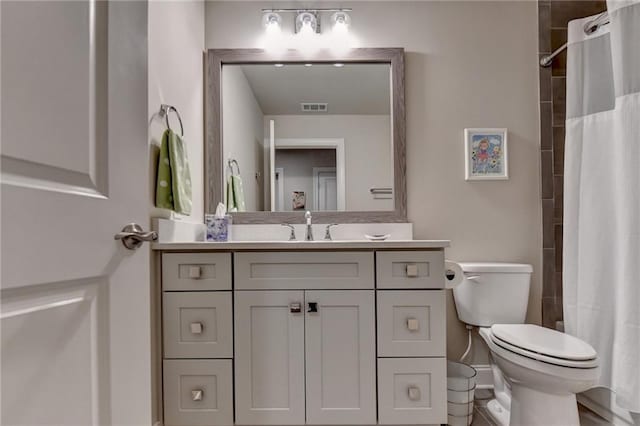 bathroom featuring vanity, toilet, visible vents, and curtained shower