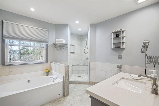 bathroom featuring a garden tub, recessed lighting, tiled shower, and vanity