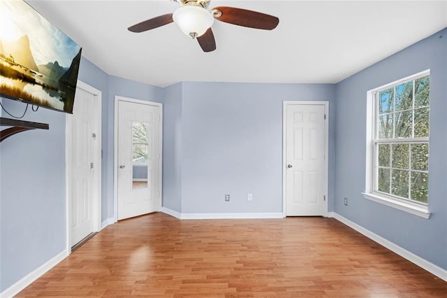 empty room featuring light wood-style flooring, baseboards, and a wealth of natural light