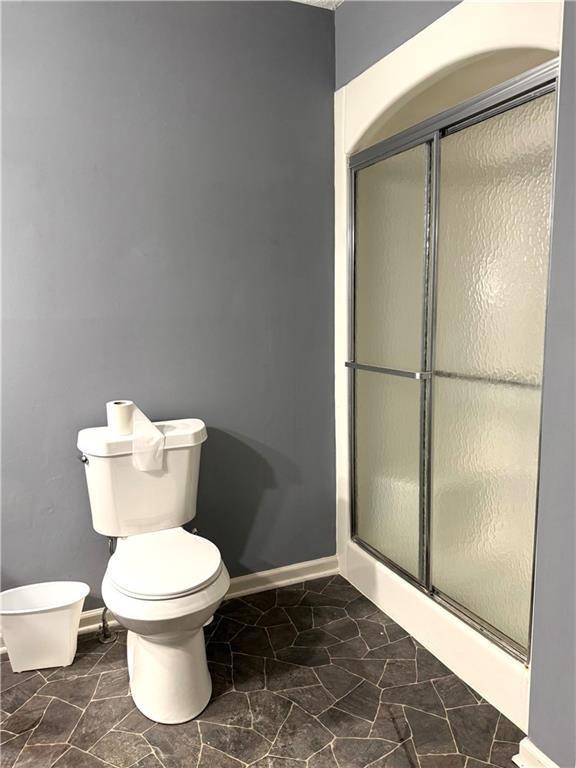 bathroom featuring toilet and walk in shower