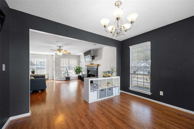 living room featuring wood-type flooring and ceiling fan with notable chandelier