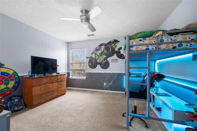 bedroom with ceiling fan, carpet floors, and a textured ceiling