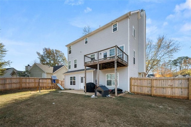 back of property with a balcony, a patio, a playground, and a lawn