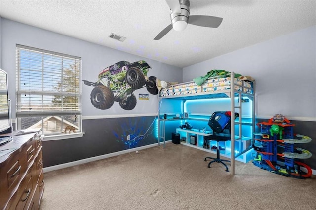 carpeted bedroom featuring ceiling fan and a textured ceiling