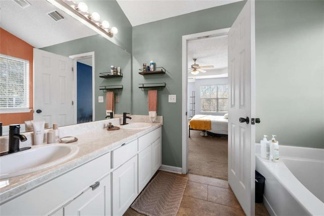 bathroom with lofted ceiling, a bathtub, tile patterned flooring, vanity, and ceiling fan