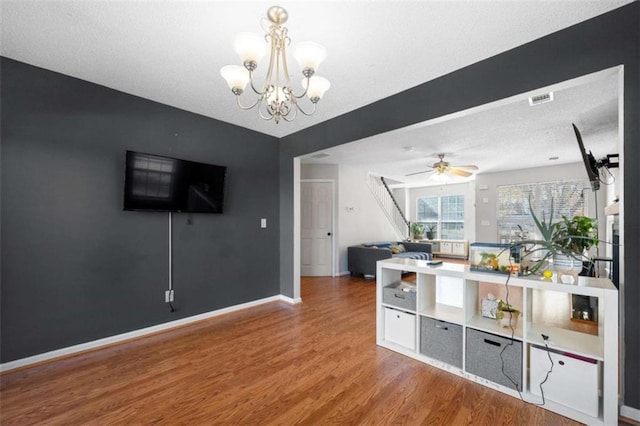 interior space featuring hardwood / wood-style flooring and ceiling fan with notable chandelier