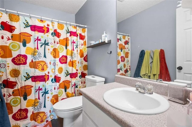 bathroom with vanity, toilet, and a textured ceiling