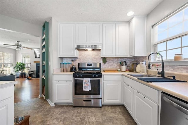 kitchen featuring stainless steel appliances, sink, white cabinets, and backsplash