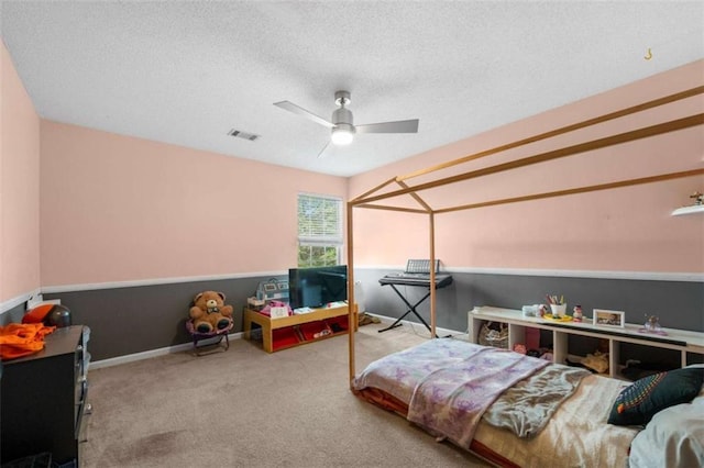 bedroom with ceiling fan, carpet flooring, and a textured ceiling