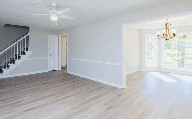 1391 Warrenton Hunt, Lawrenceville, GA 30043 - unfurnished living room with stairs, a chandelier, light wood-style floors, and ceiling fan