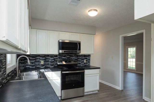 1391 Warrenton Hunt, Lawrenceville, GA 30043 - kitchen with appliances with stainless steel finishes, backsplash, white cabinets, a textured ceiling, and dark countertops