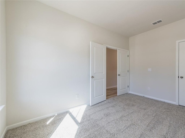 unfurnished room featuring light carpet