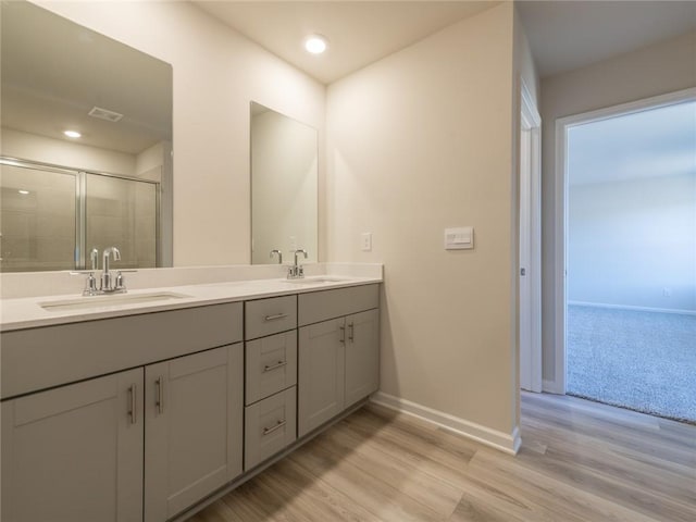 bathroom featuring hardwood / wood-style flooring, vanity, and an enclosed shower