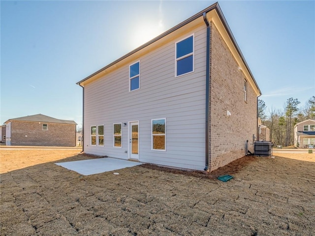 rear view of property with central AC unit and a patio area