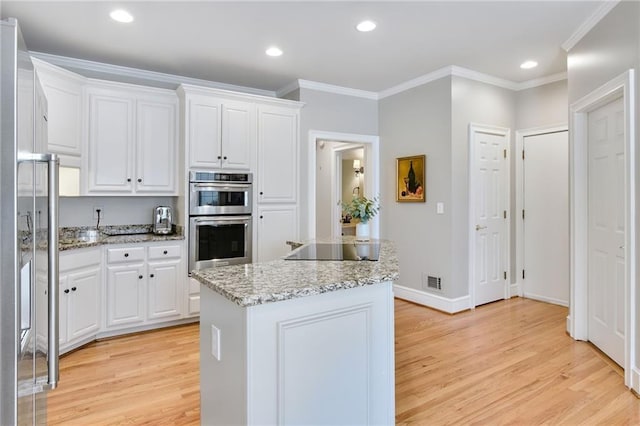 kitchen with light hardwood / wood-style floors, a center island, stainless steel double oven, white cabinets, and black electric cooktop