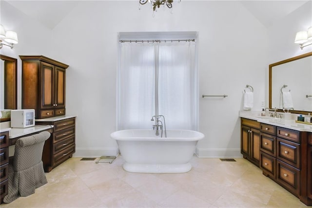 bathroom with a tub, tile patterned floors, vanity, and lofted ceiling