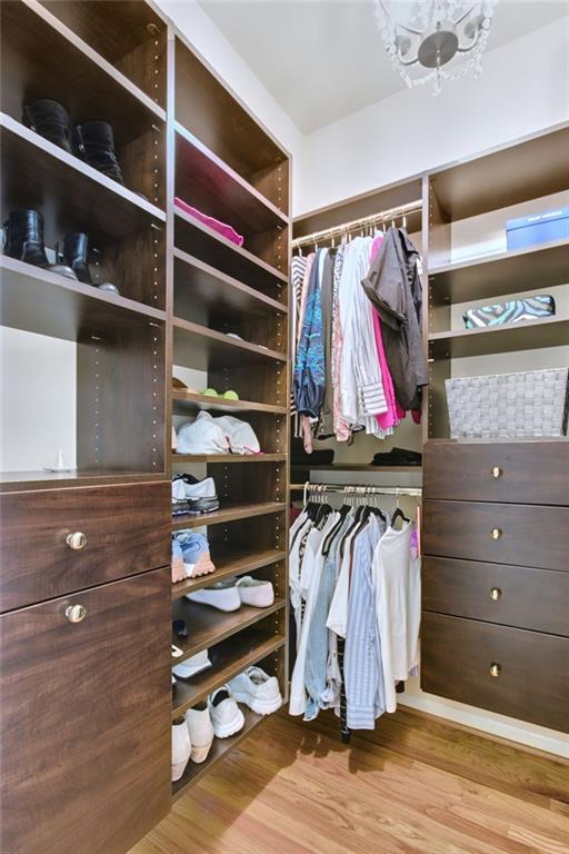 walk in closet with light hardwood / wood-style floors