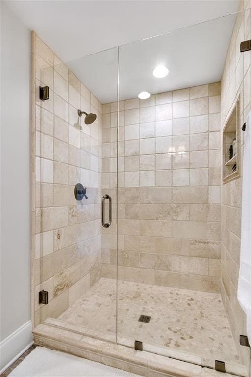 bathroom featuring a shower with door