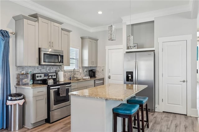 906 Sims St SW, Atlanta, GA 30603 - kitchen with a center island, ornamental molding, light wood-style flooring, appliances with stainless steel finishes, and a sink