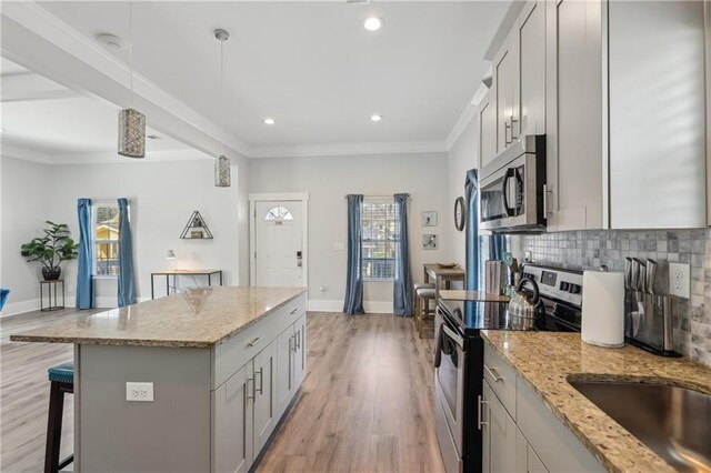 906 Sims St SW, Atlanta, GA 30603 - kitchen with stainless steel microwave, a kitchen breakfast bar, electric range oven, crown molding, and decorative backsplash